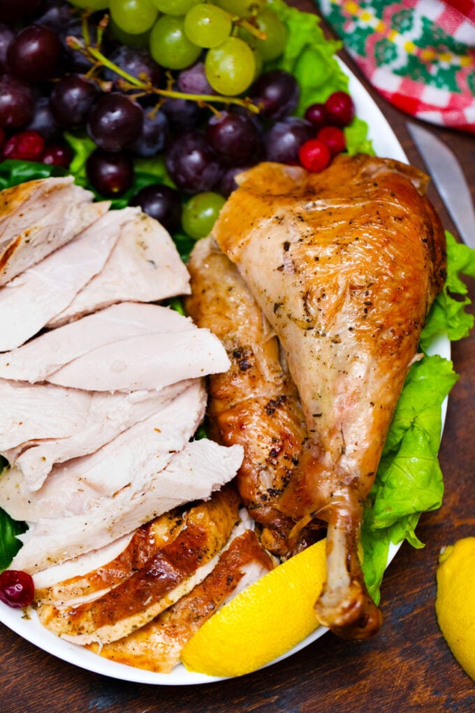 Carved juicy herb roasted turkey on a serving platter.