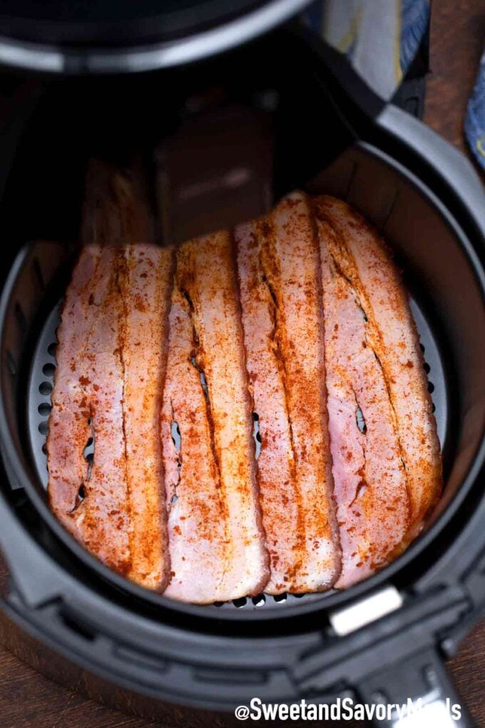 bacon strips seasoned and placed in the air fryer basket