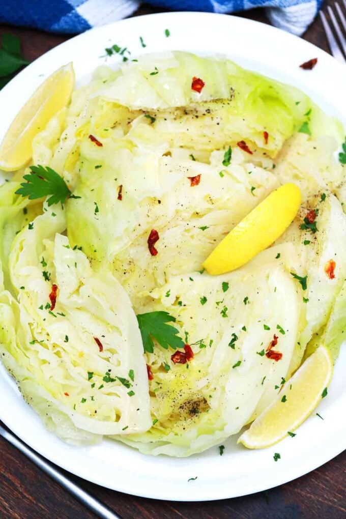 boiled cabbage wedges with parsley and red pepper flakes and lemon wedges