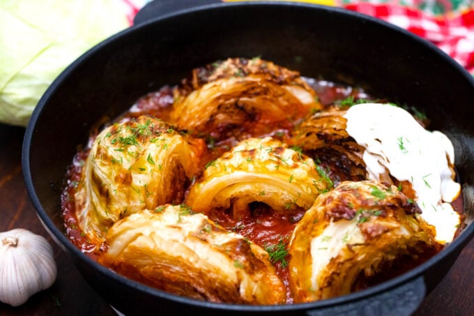 Caramelized cabbage wedges in tomato sauce and topped with sour cream.