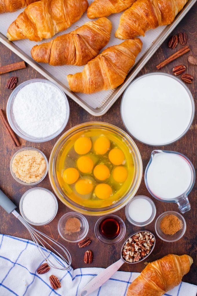 Croissant French toast casserole ingredients in bowls on a table.