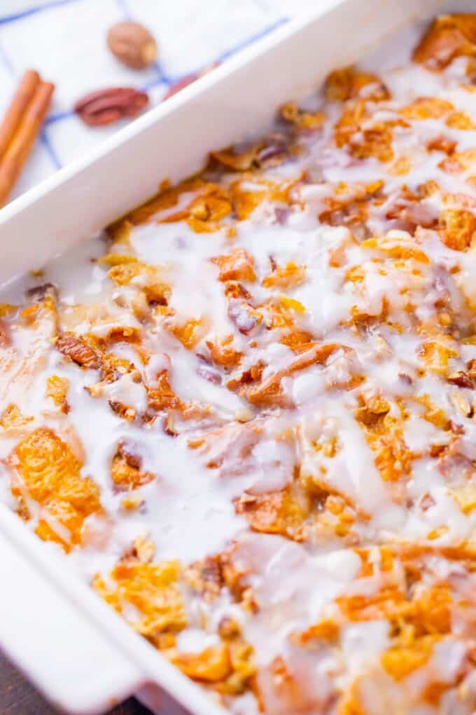 Croissant French toast casserole topped with vanilla glaze.