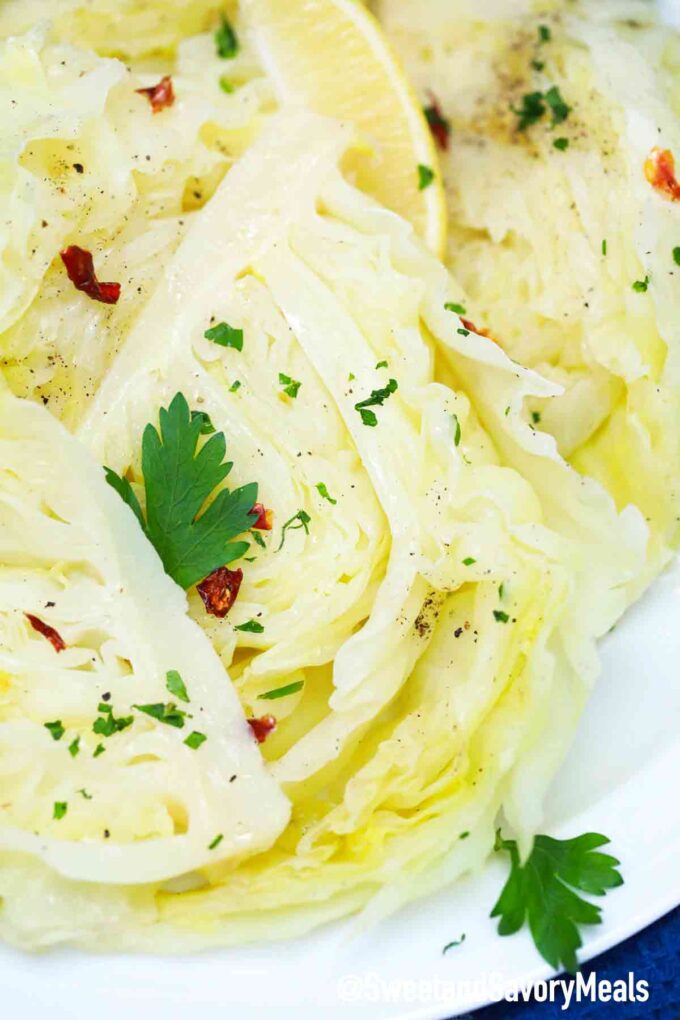 cooked cabbage on a plate topped with parsley and red pepper flakes