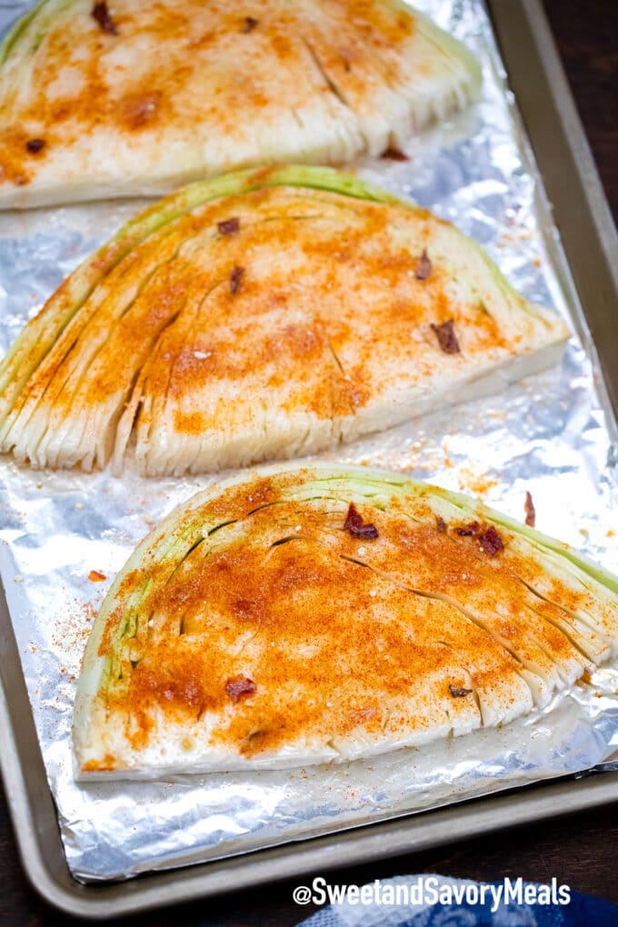 seasoned cabbage slices on a baking sheet