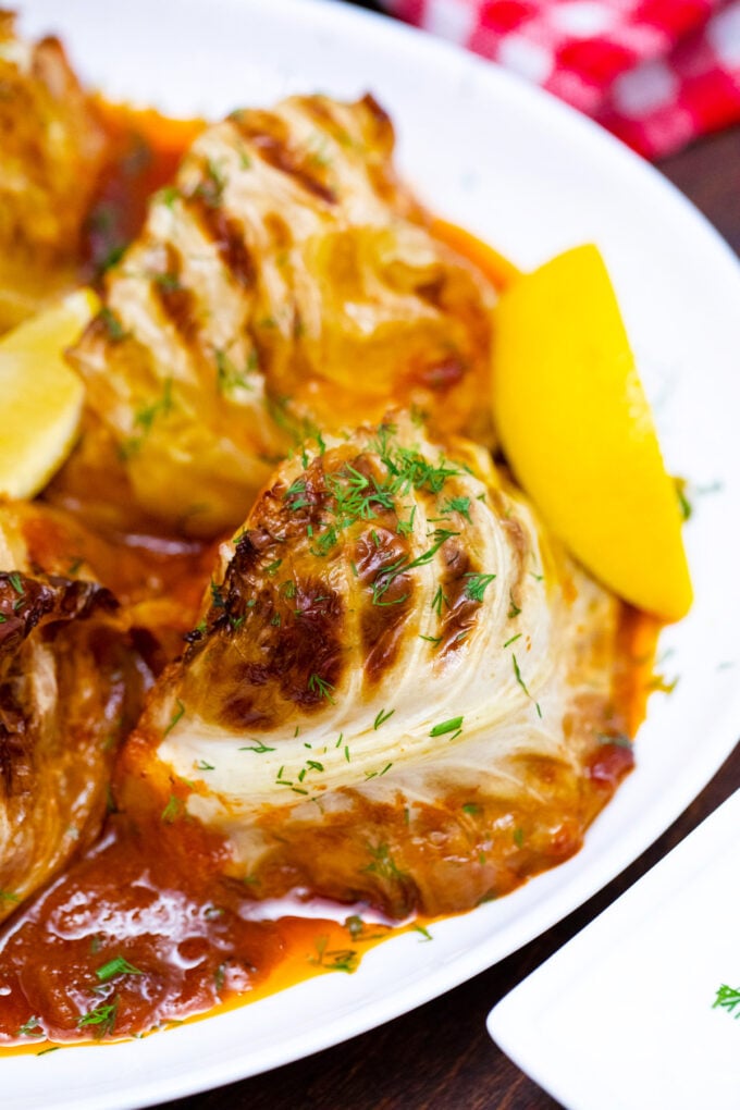 A plate of caramelized cabbage wedges in tomato sauce.