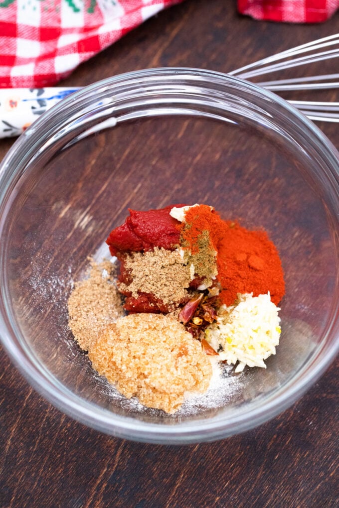 Brown sugar, paprika, tomato paste and spices in a bowl.