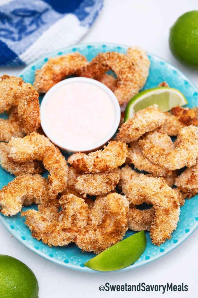 air fryer coconut shrimp with sweet chili sauce on the side and sliced lime