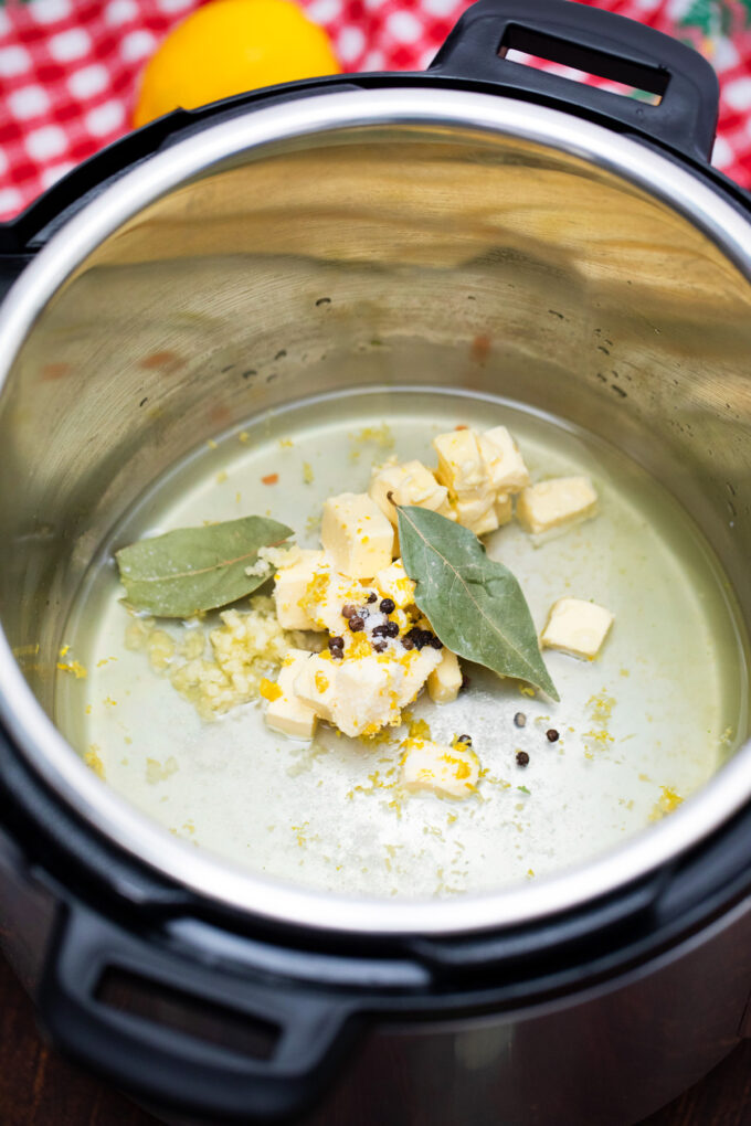 Butter, broth, lemon zest, and herbs in the Instant Pot.