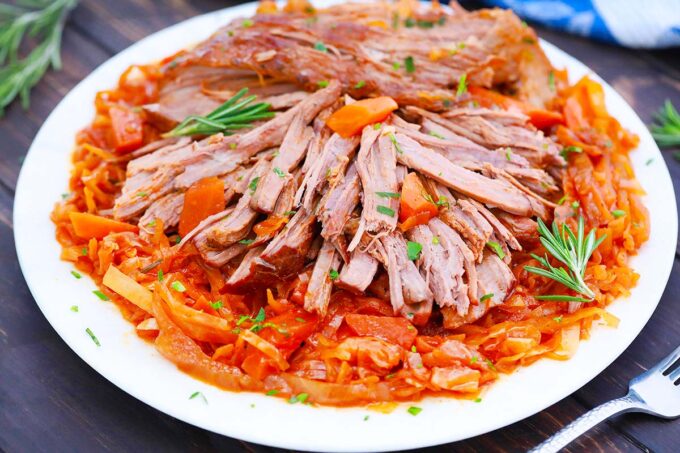 A plate of shredded German pot roast with braised cabbage.