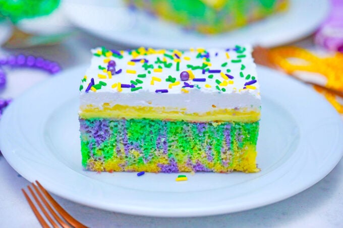 A slice of King cake poke cake.