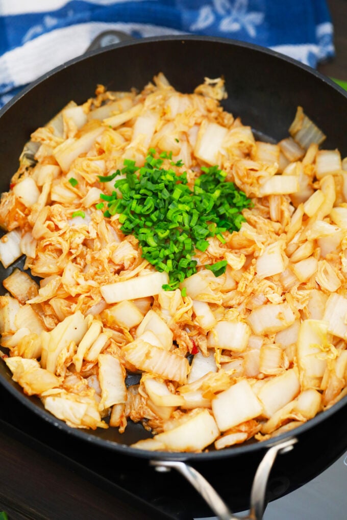 Overhead shot of sauteed Napa cabbage topped with green onions.