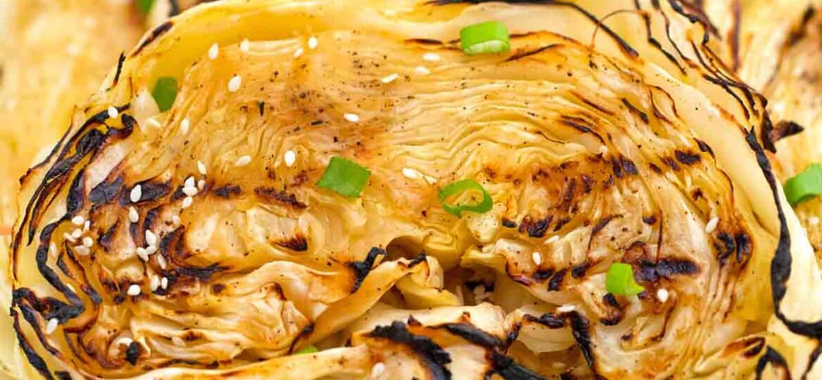 teriyaki cabbage steaks on a plate with lemon wedges