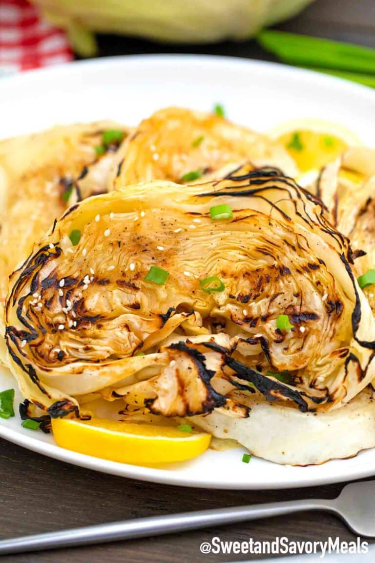 teriyaki cabbage steaks on a plate with lemon wedges