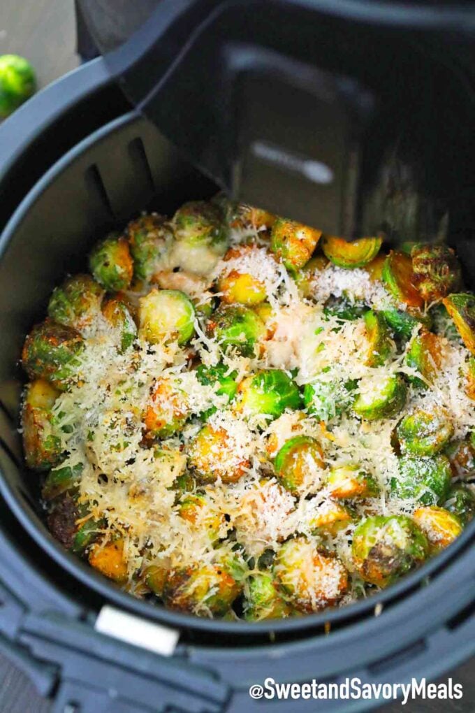 brussel sprouts sprinkled with shredded parmesan cheese in the air fryer basket