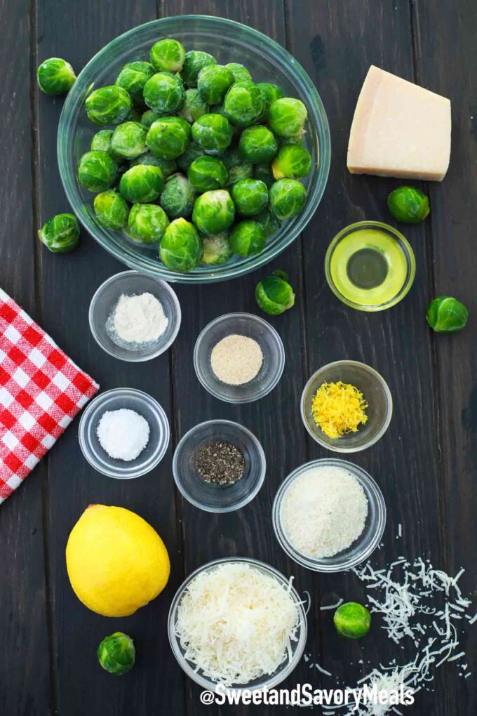 fresh brussel sprouts with seasoning and shredded cheese on a wooden board