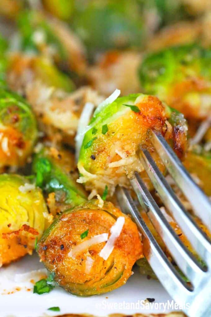crispy air fryer brussel sprouts garnished with shredded parmesan cheese