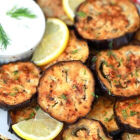 air fryer eggplant on a plate with tzatziki sauce