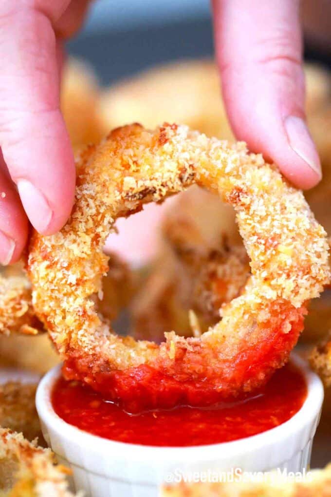 Crispy air fryer onion rings dipped in ketchup 