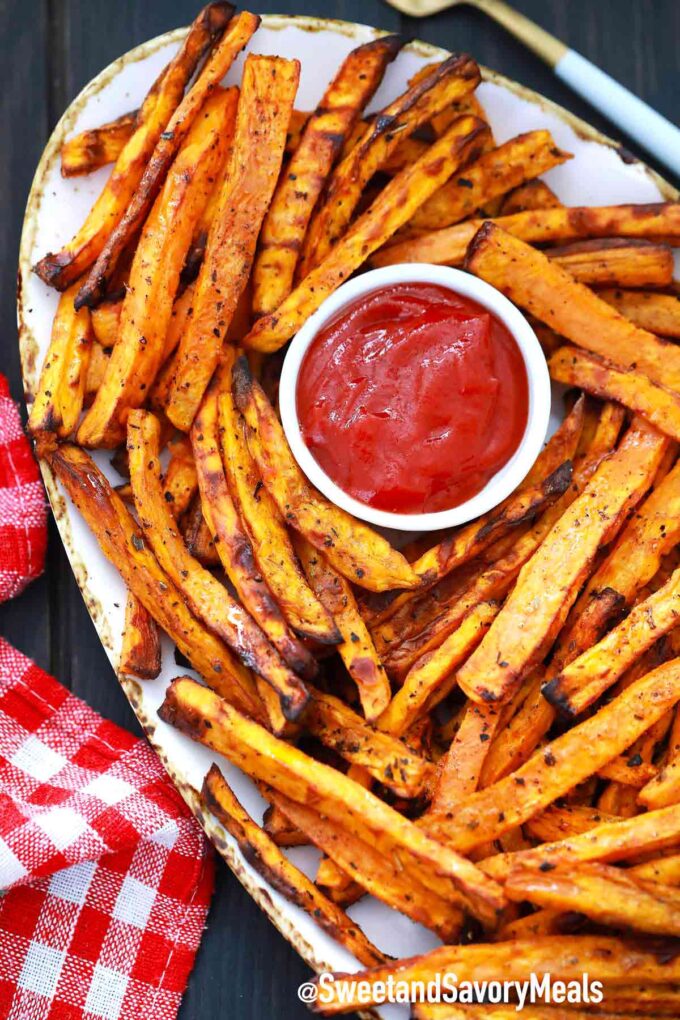 crispy sweet potato fries with ketchup on a white plate