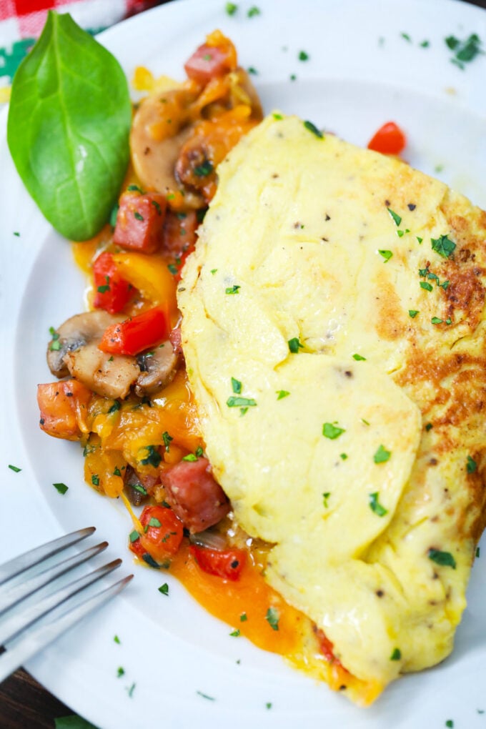 Overhead shot of creamy omelet with veggies and ham.