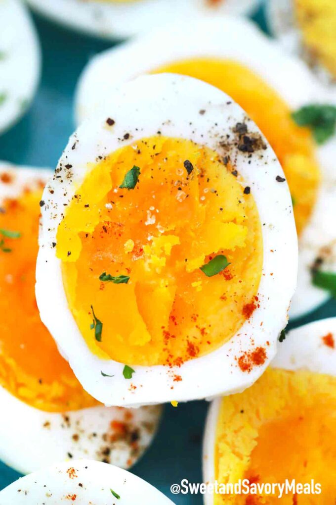 Soft boiled eggs sliced in half and garnished with paprika and black pepper