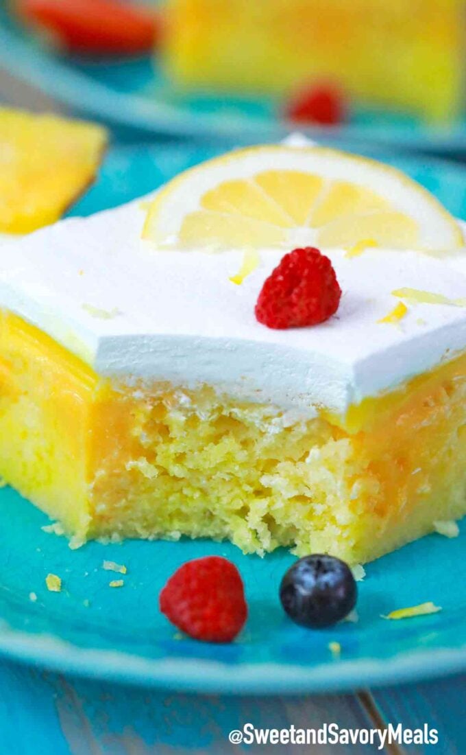 lemon poke cake topped with whipped cream