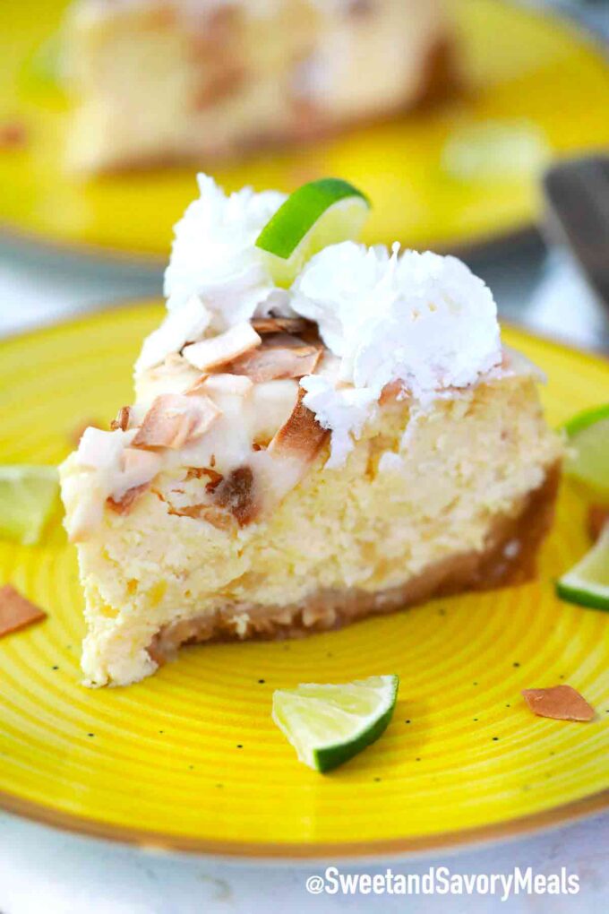 a slice of Pina Colada cheesecake with toasted coconut and whipped cream