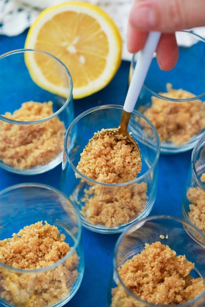 Adding graham cracker crust layer to glasses.