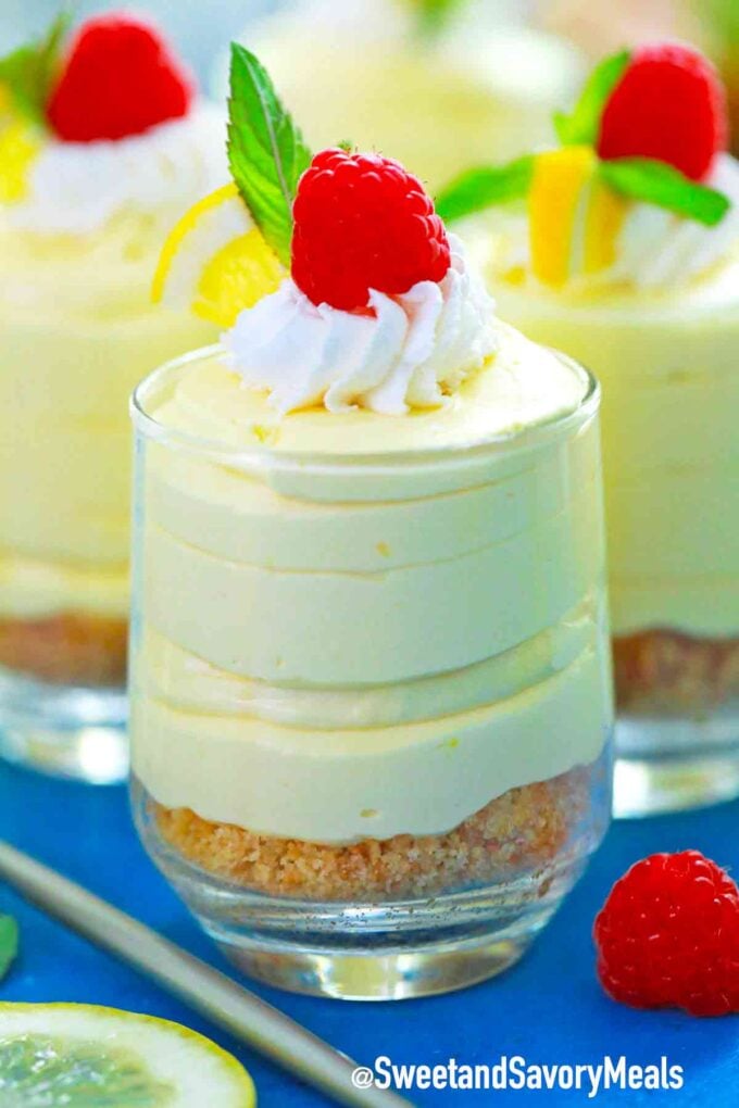 lemon mousse topped with whipped cream raspberries and mint
