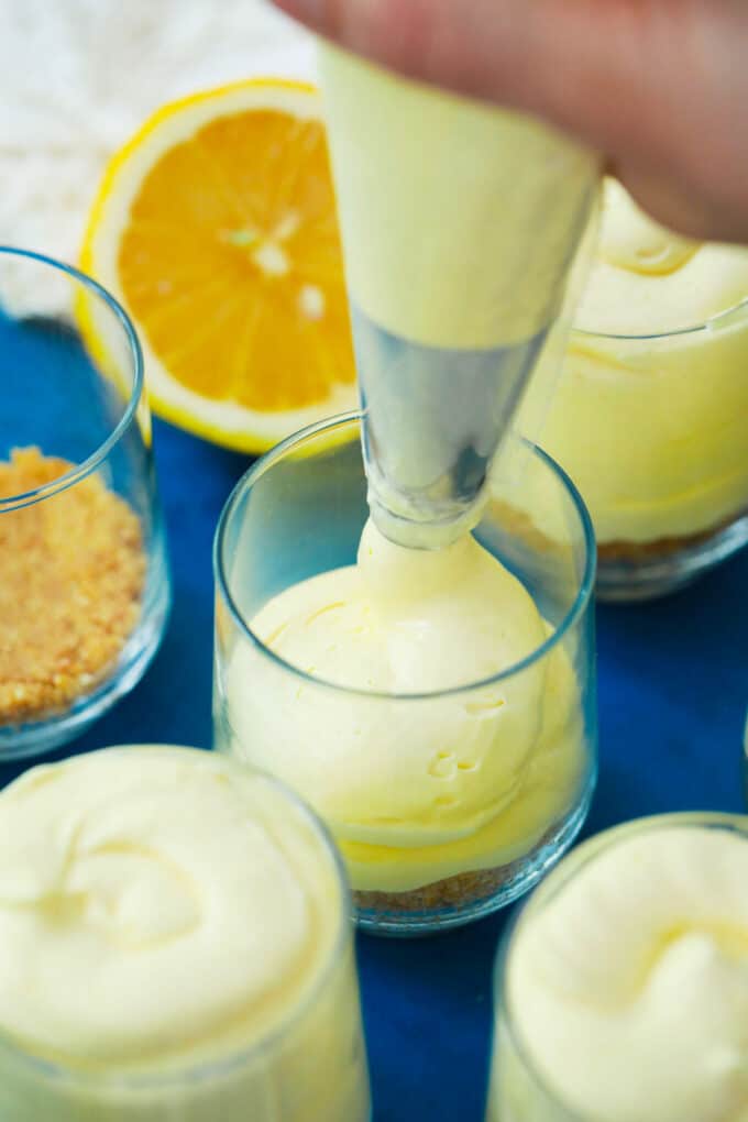 Piping no bake lemon mousse into serving glasses.
