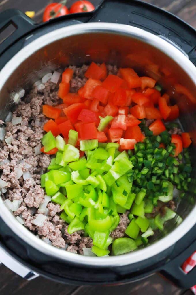 Browned beef and diced bell peppers in the Instant Pot.