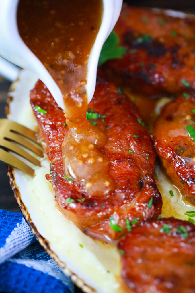 Pouring honey garlic sauce over Instant Pot honey garlic pork chops.
