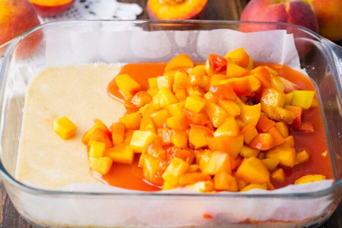 Adding peach mixture on top of dough layer.