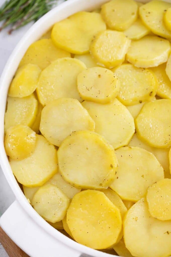 Cooked scalloped potatoes arranged in a baking dish.