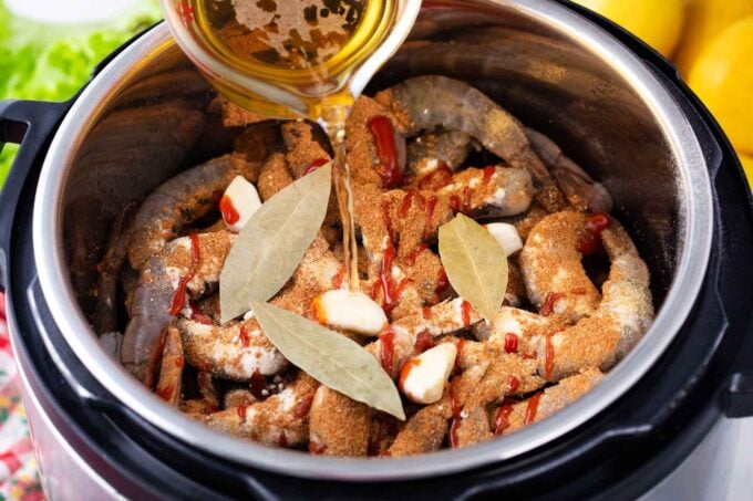 Adding beer on top of shrimp boil ingredients in the instant pot.