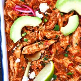 chicken tinga with avocado slices, cotija cheese, lime and red onion