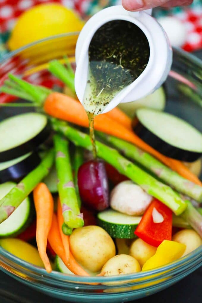 Pouring marinade over chopped veggies.