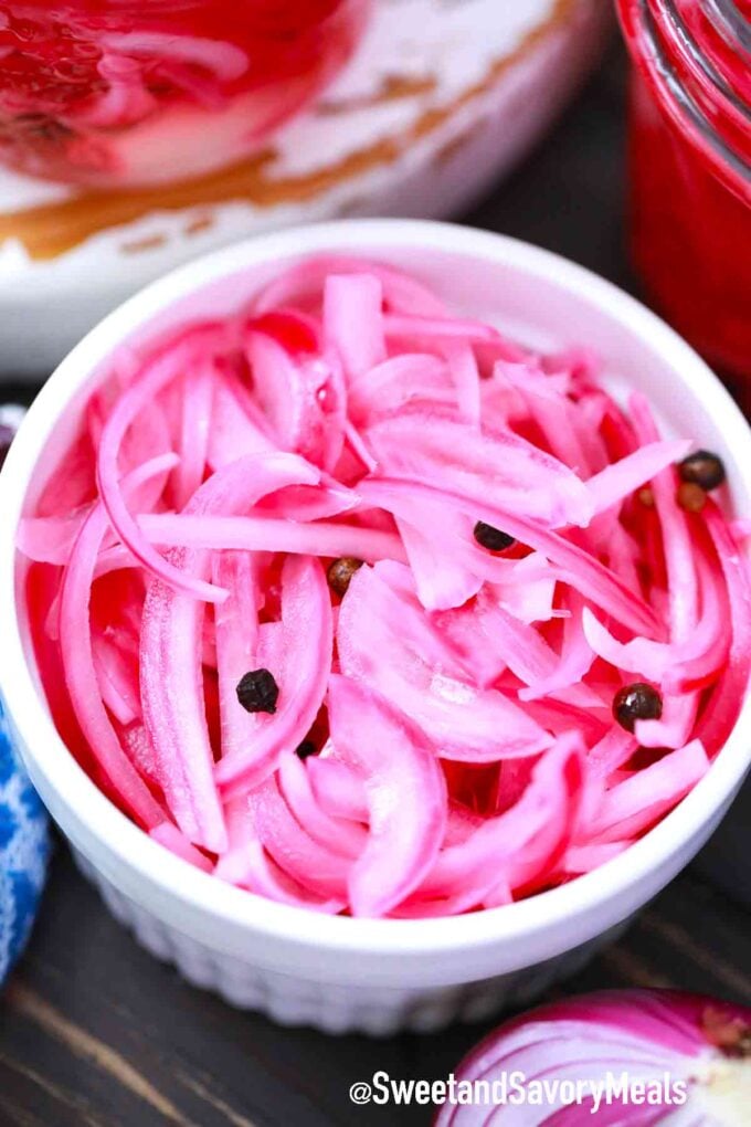 pickled red onions in a white jar