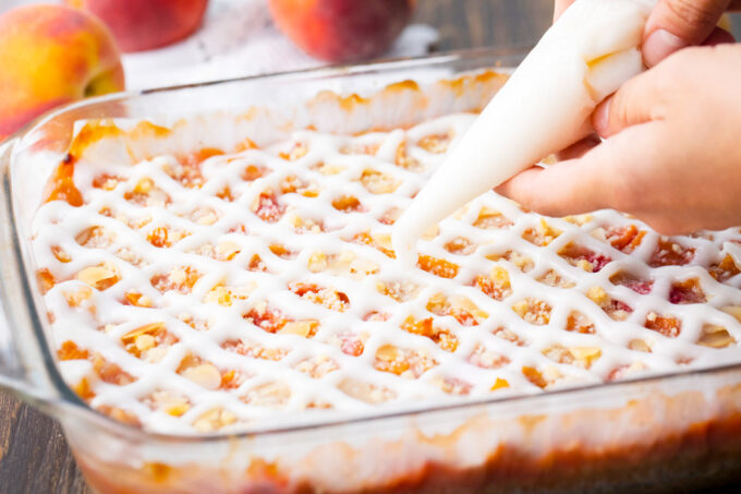 Glazing peach crumb bars.
