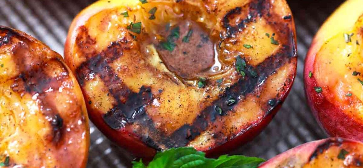 grilled peaches on a baking sheet