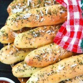 homemade breadsticks covered with a kitchen towel