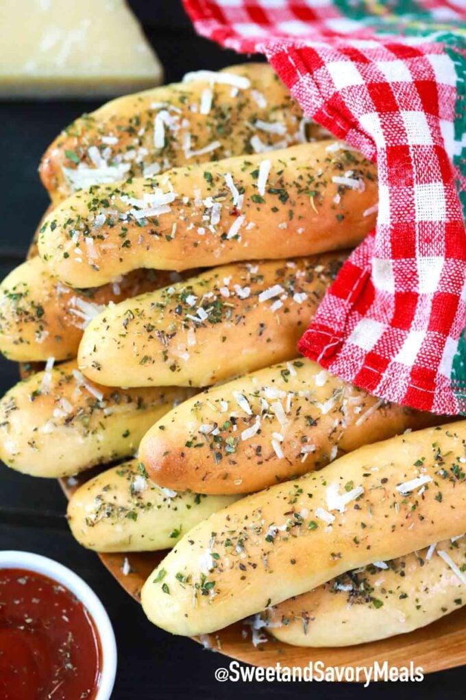 homemade breadsticks covered with a kitchen towel