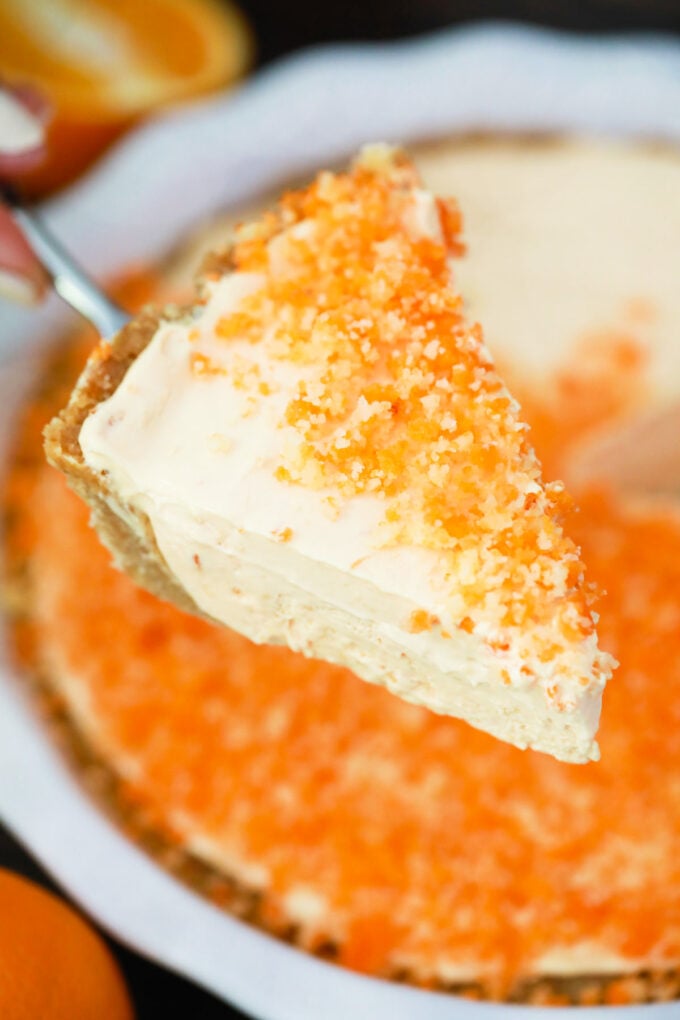 A slice of orange creamsicle pie on a serving spatula.