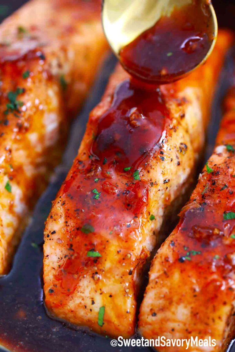 pouring honey garlic sauce on salmon fillets