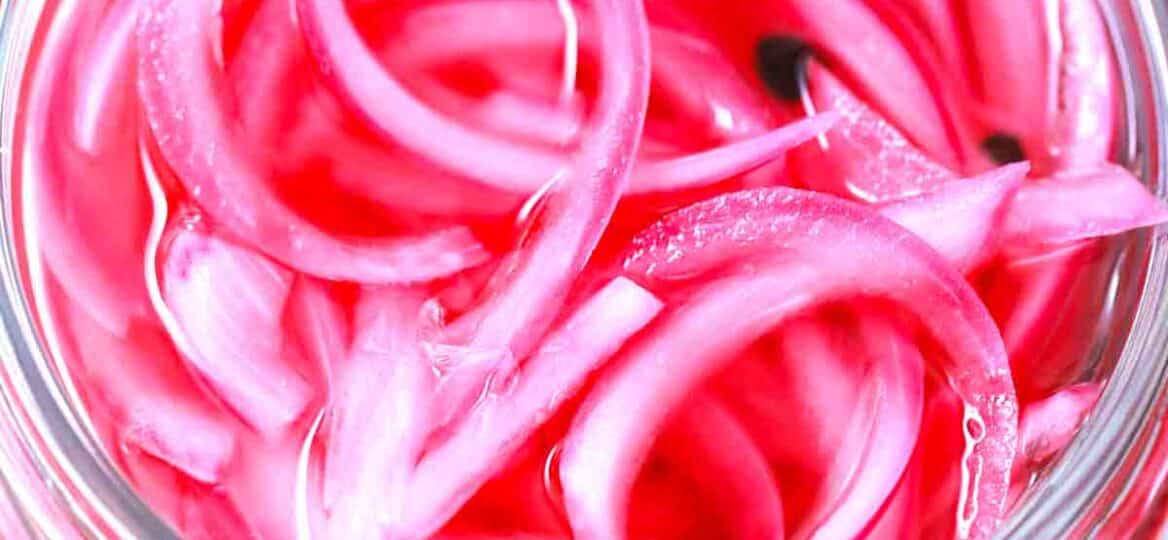 pickled red onions in a glass jar