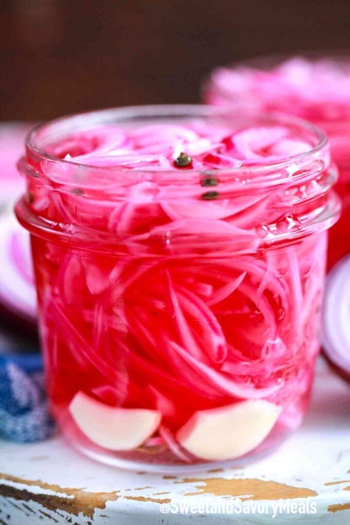 pickled red onions with garlic in a jar