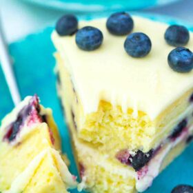 a slice of lemon blueberry cake with blueberry garnish