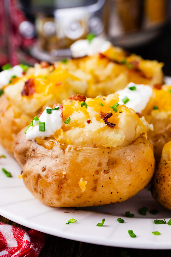 Homemade slow cooker baked potatoes topped with cheese and sour cream.