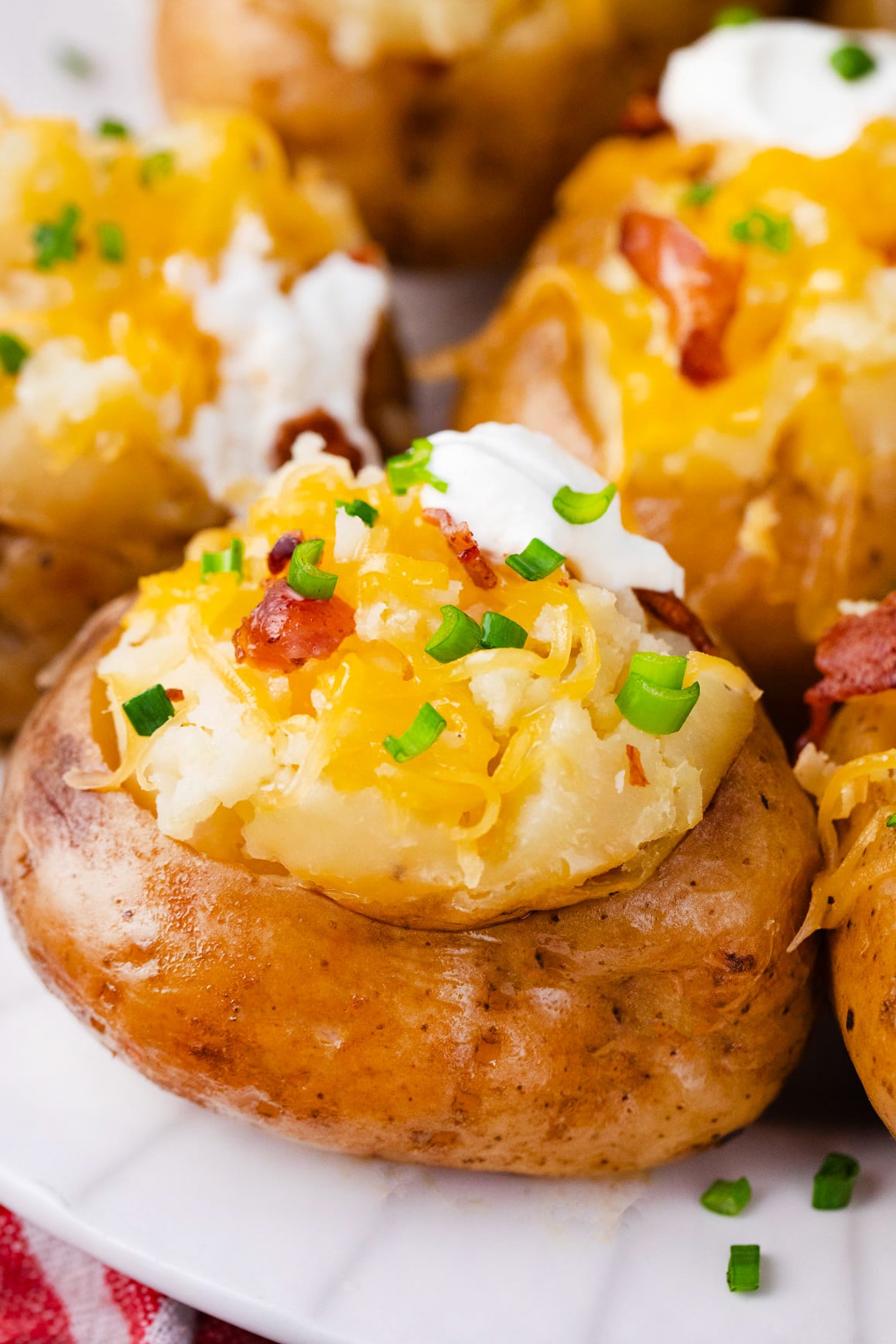 Slow cooker baked potatoes topped with cheese and chives.