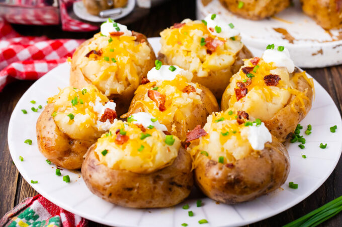 Tender slow cooker baked potatoes topped with sour cream, cheese, and bacon.